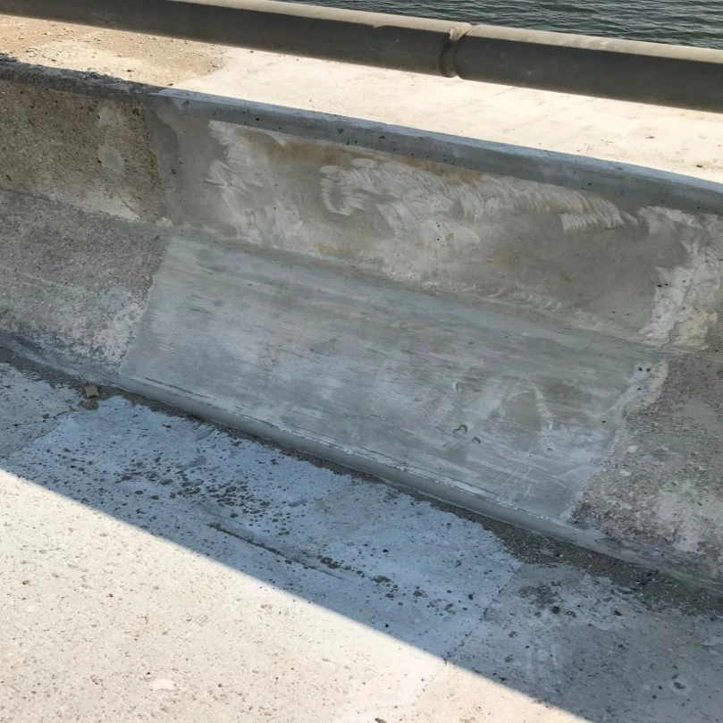 An image of a side of a bridge deck showing where a concrete link slab was placed to cover the deck joint after finishing is completed.